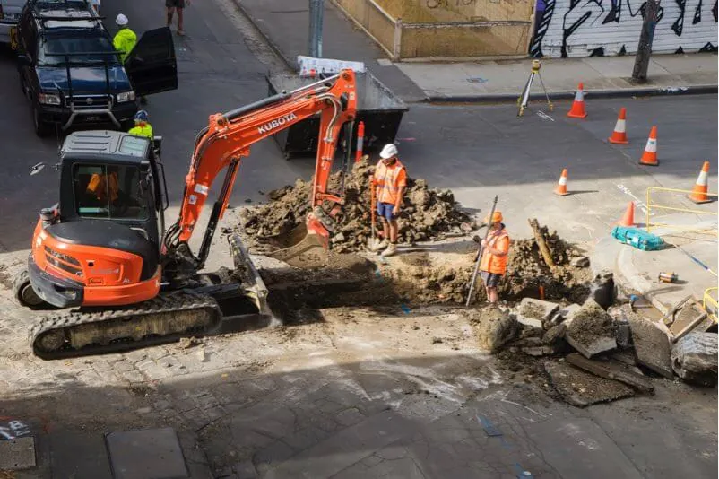 Municipal crew excavating a city street to reach buried water and sewer infrastructure